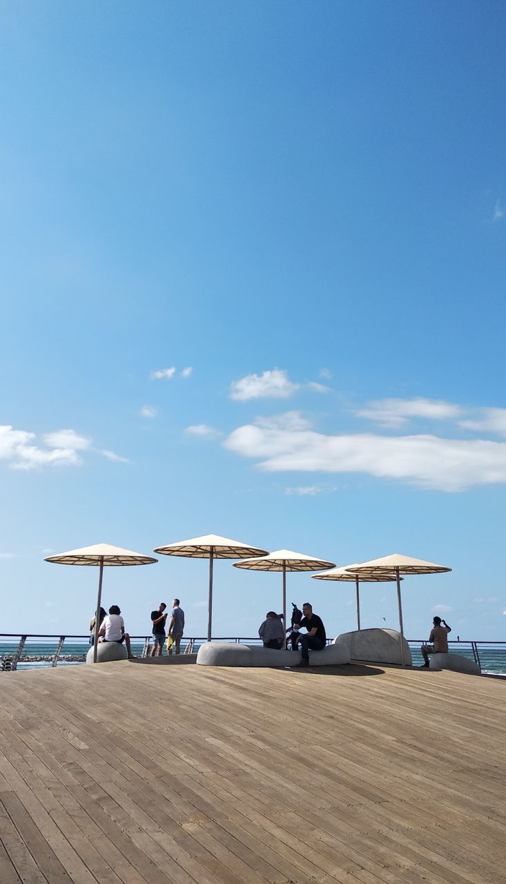 PEOPLE AT BEACH AGAINST SKY