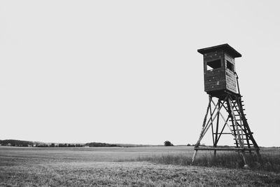 Low angle view of tower on field against clear sky