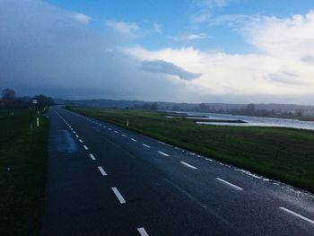 Road by landscape against sky