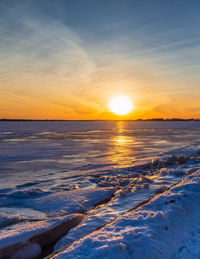 Scenic view of frozen sea against sky during sunset