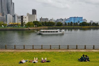 Man sitting on bench in front of river