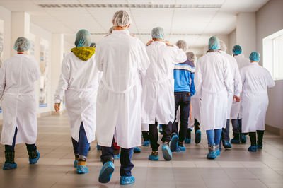 Rear view of people walking in corridor