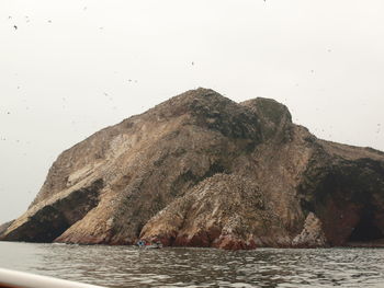 Rocks in sea against clear sky