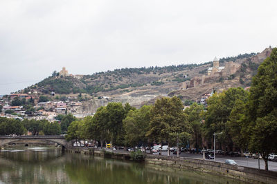 Scenic view of river by town against clear sky