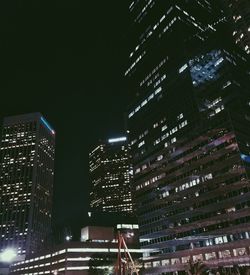 Low angle view of illuminated skyscrapers against sky at night