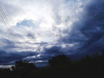 Low angle view of silhouette trees against sky