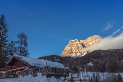 Built structure on snow covered landscape against sky