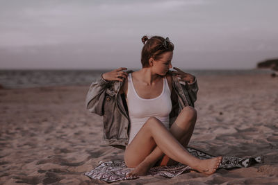 Young woman sitting on beach