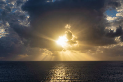 Scenic view of sea against sky during sunset with sunrays