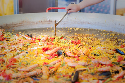 Cropped image of hand preparing food in large container