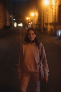 Portrait of young woman standing at night