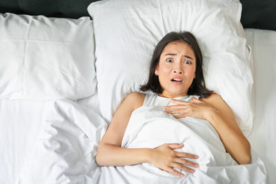 Portrait of young woman sleeping on bed at home