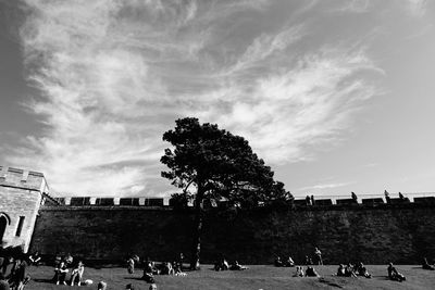 People at town square against cloudy sky