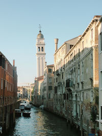 View of canal amidst buildings against clear sky