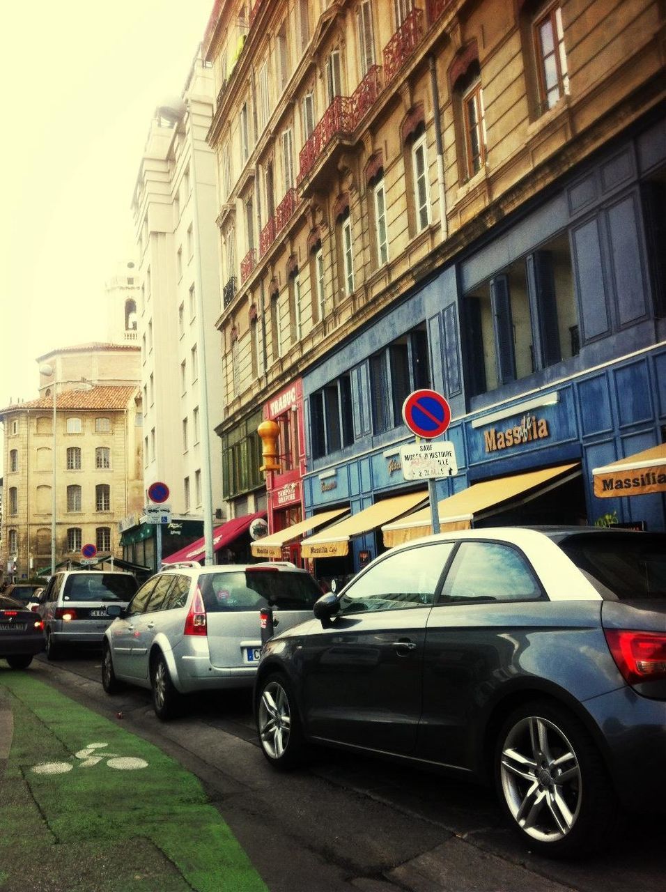 transportation, land vehicle, mode of transport, building exterior, architecture, car, built structure, street, road, bicycle, city, parking, stationary, parked, building, city street, road marking, travel, day, on the move