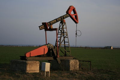 Traditional windmill on field against sky