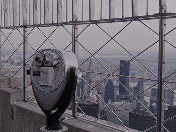 Close-up of coin-operated binoculars against cityscape