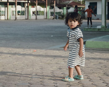 Portrait of boy standing on road