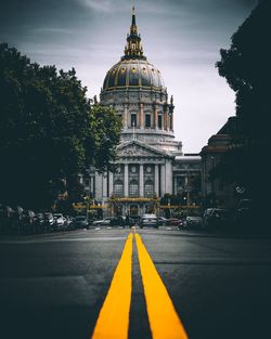 Double yellow line on street in city against cathedral