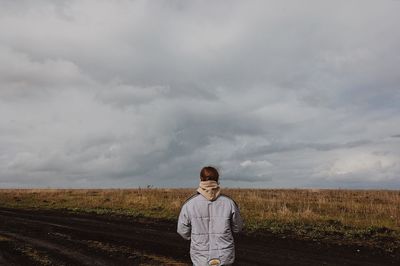 Full length of man standing on field against sky