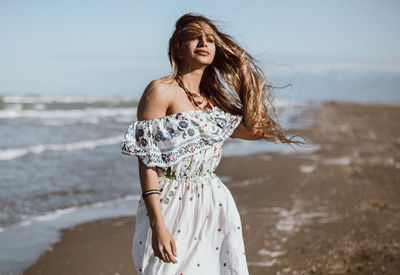Young woman standing at beach