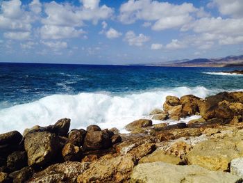 Scenic view of rocks in sea against sky
