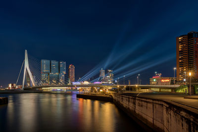 Illuminated bridge over river at night