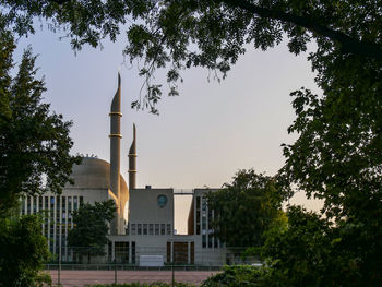 Low angle view of trees and buildings against sky