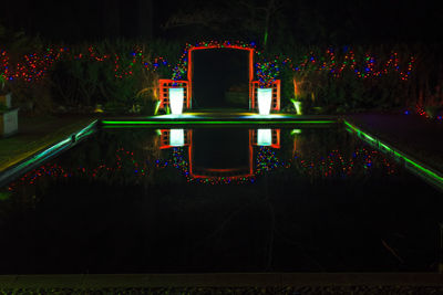 View of swimming pool in park at night