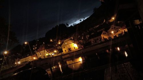 Illuminated city against sky at night