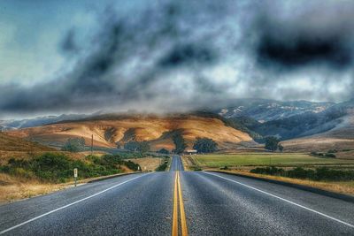 Empty road with mountains in background