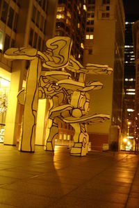 Illuminated street amidst buildings in city at night