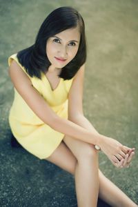 Portrait of smiling young woman sitting outdoors