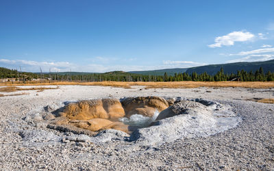 View of shell spring in biscuit basin with sky in background at yellowstone park