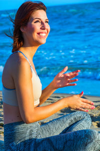 Side view of a smiling young woman in swimming pool