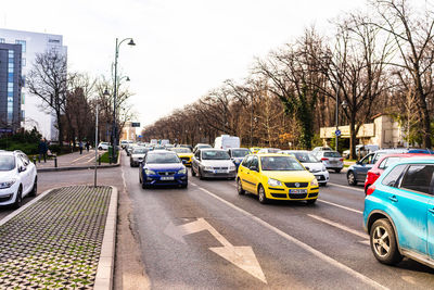 Cars on road against sky in city