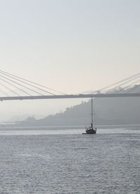 Sailboat in sea against clear sky