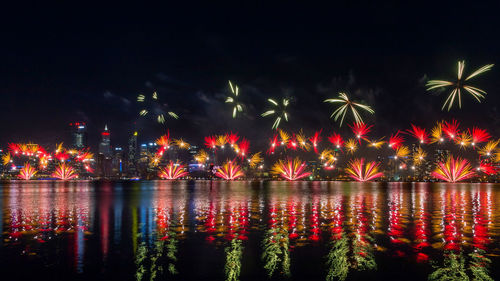 View of firework display over river at night