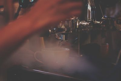 Close-up of hand pouring coffee in cafe