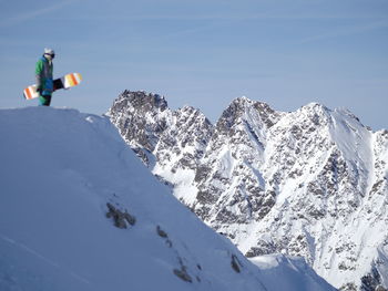 Man holding snowboard on landscape