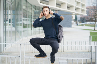 Young man with headphones on city street