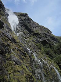 Low angle view of waterfall against sky