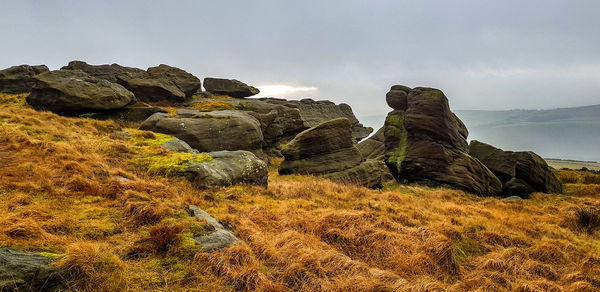 Rock formations by sea against sky