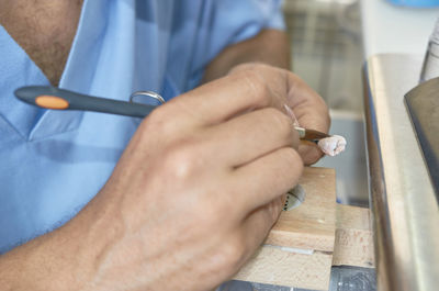 Midsection of man working on wood