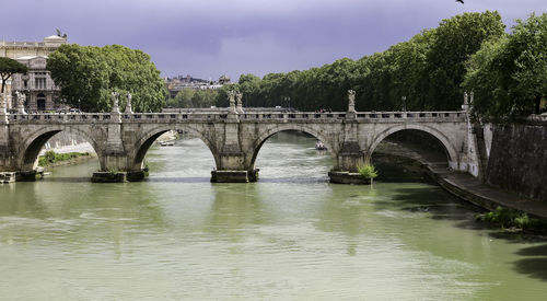 Arch bridge over river against sky