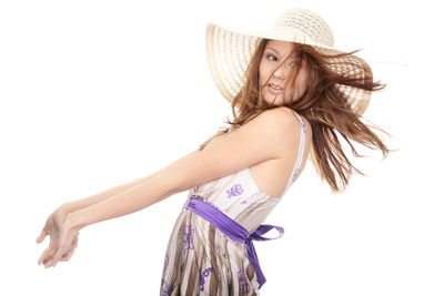 Portrait of young woman wearing hat against white background