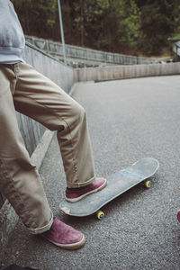 Low section of man skateboarding on road