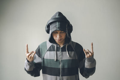 Portrait of man standing against gray background