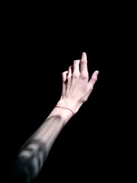 Cropped image of hand against black background