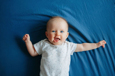 Baby girl lying on bed at home